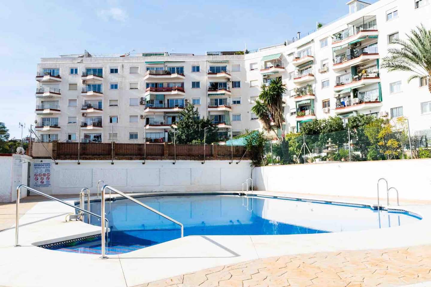 Piscina comunitaria y jardines de la urbanización de Oasis en Playamar